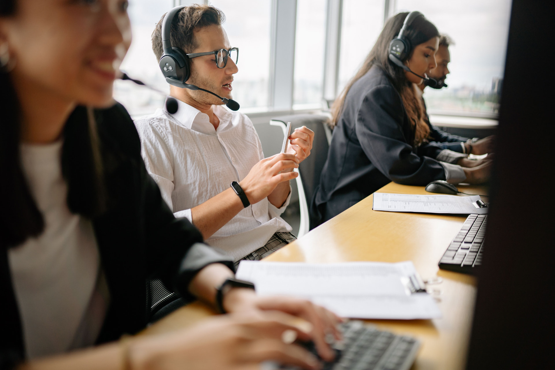 Equipo de atención al cliente atendiendo llamadas con auriculares